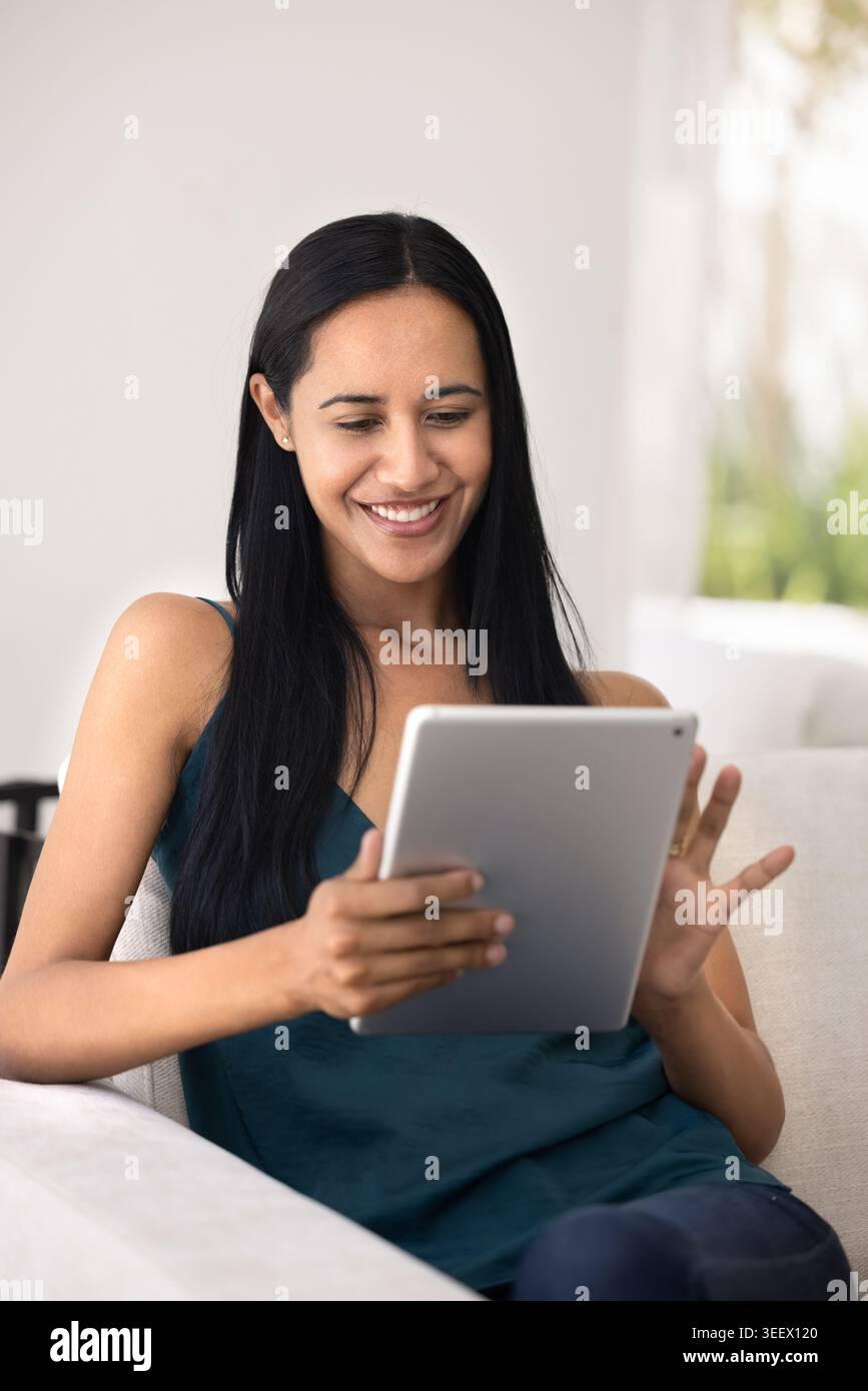 Pretty woman using digital tablet at home Stock Photo