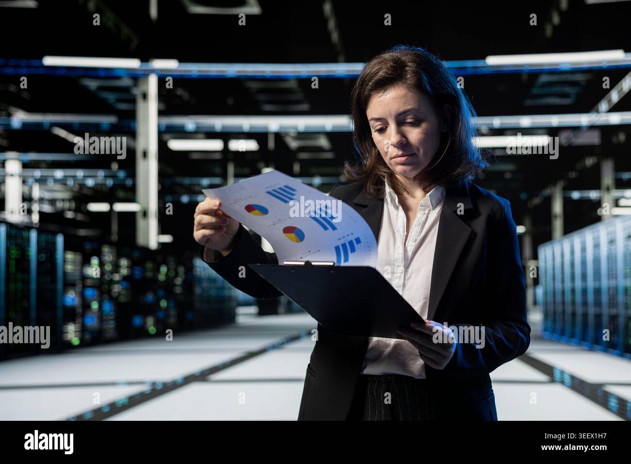 Server farm IT professional looking over maintenance diagnostic reports to optimize infrastructure performance. Data center admin crosschecking technical files to prevent unexpected system rigs bugs Stock Photo