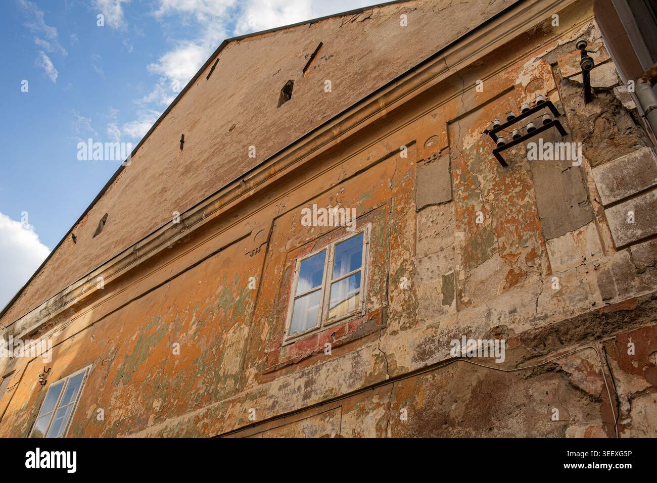 Weathered historic building facade with peeling plaster texture Stock Photo