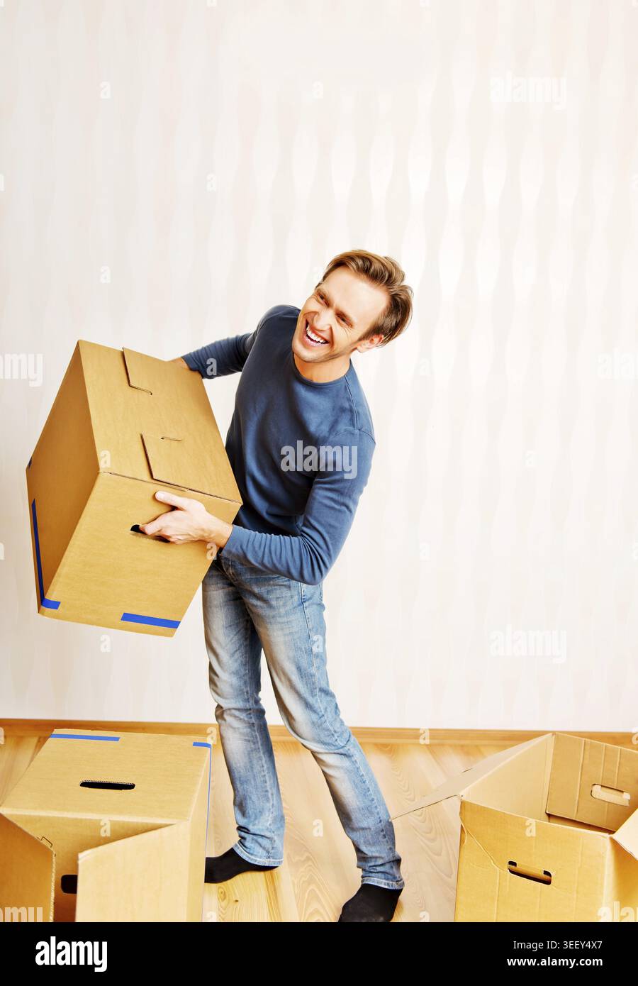 Smiling young man carrying many cardboard boxes Stock Photo