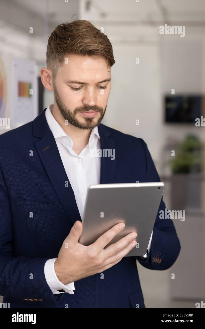 Serious businessman working on tablet in workspace Stock Photo