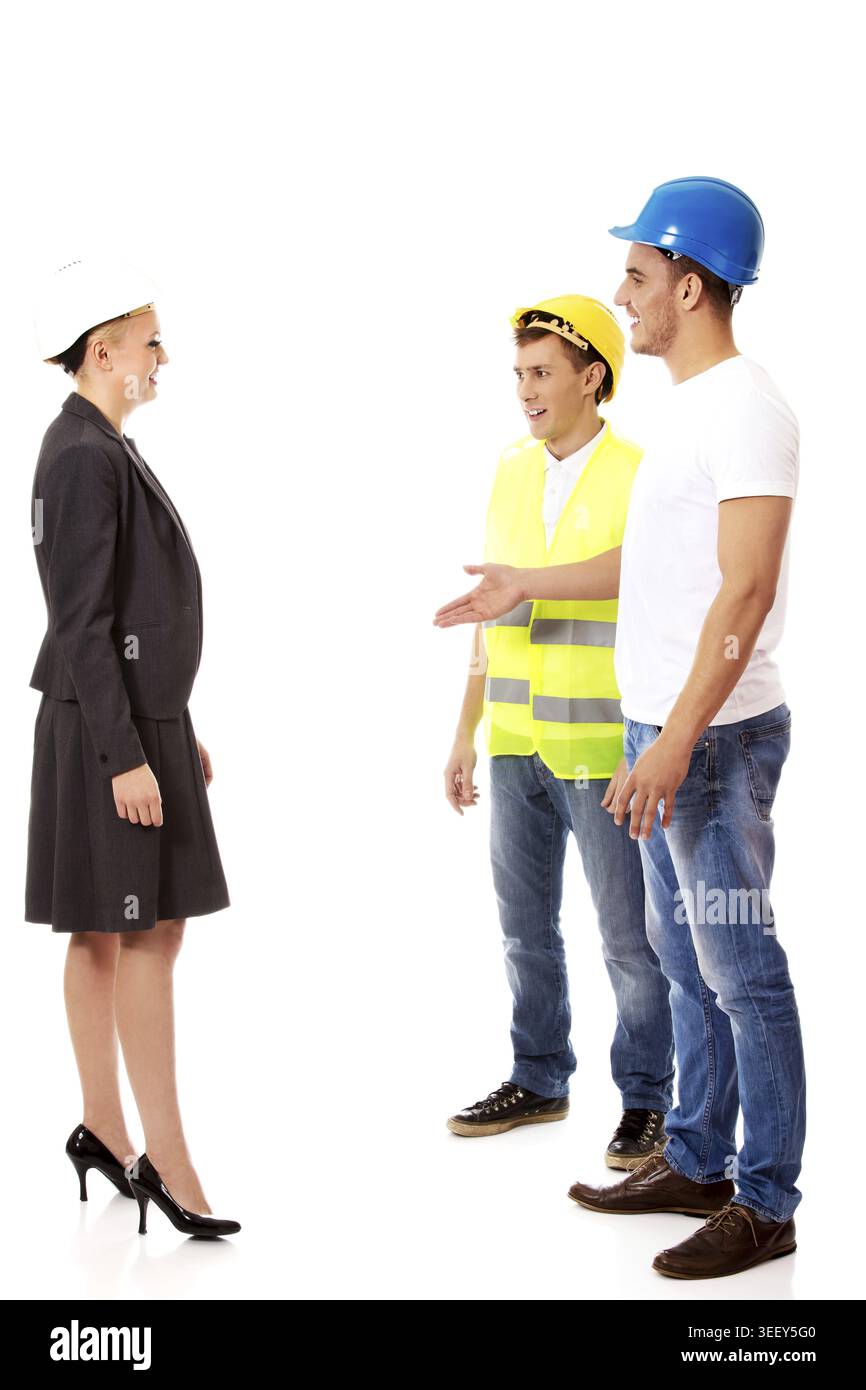Female engineer talking with two builders Stock Photo