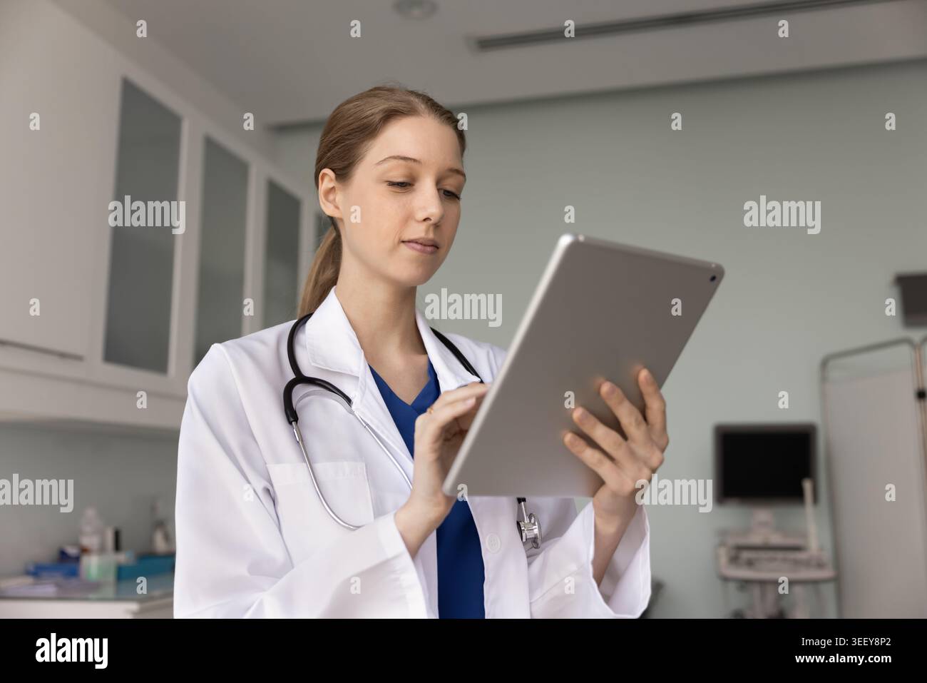 Nurse checking patient data on digital tablet in clinic Stock Photo