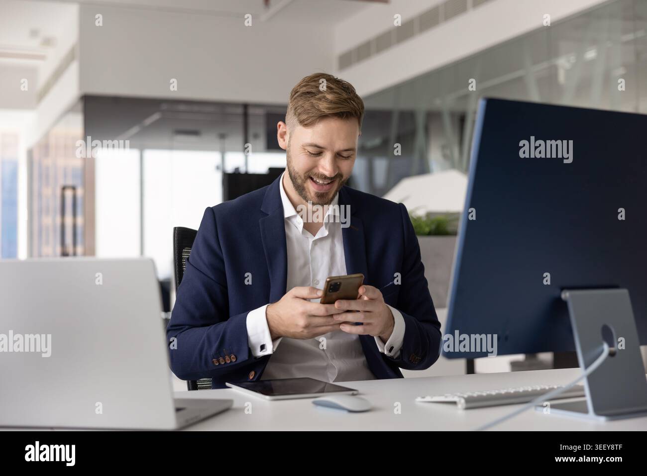 Smiling professional man, office employee using smartphone Stock Photo