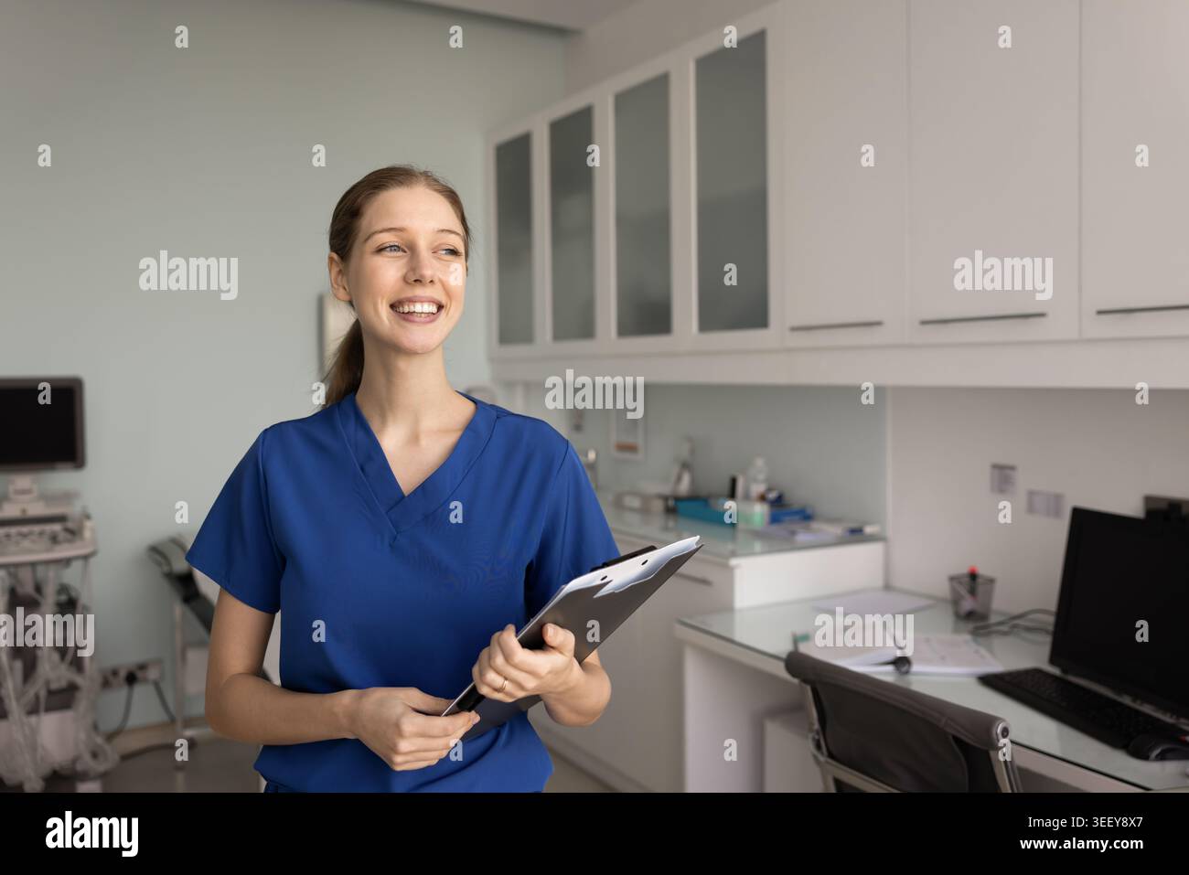 Portrait of female nurse in medical scrubs holding clipboard Stock Photo