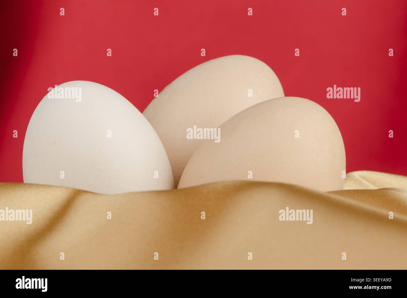 Eggs, Three eggs in the bowl on a red background Stock Photo