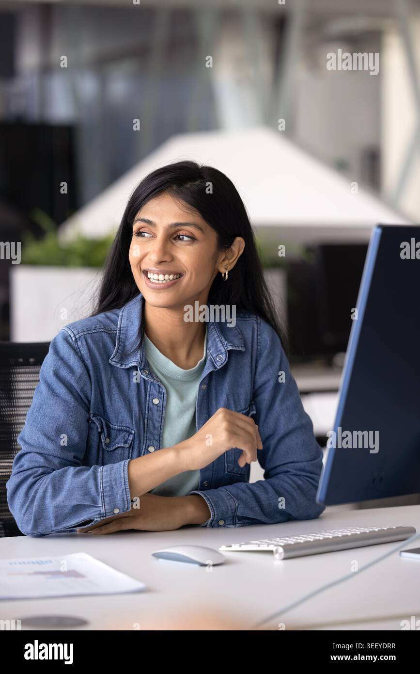 Indian businesslady sitting at desk in modern workplace Stock Photo