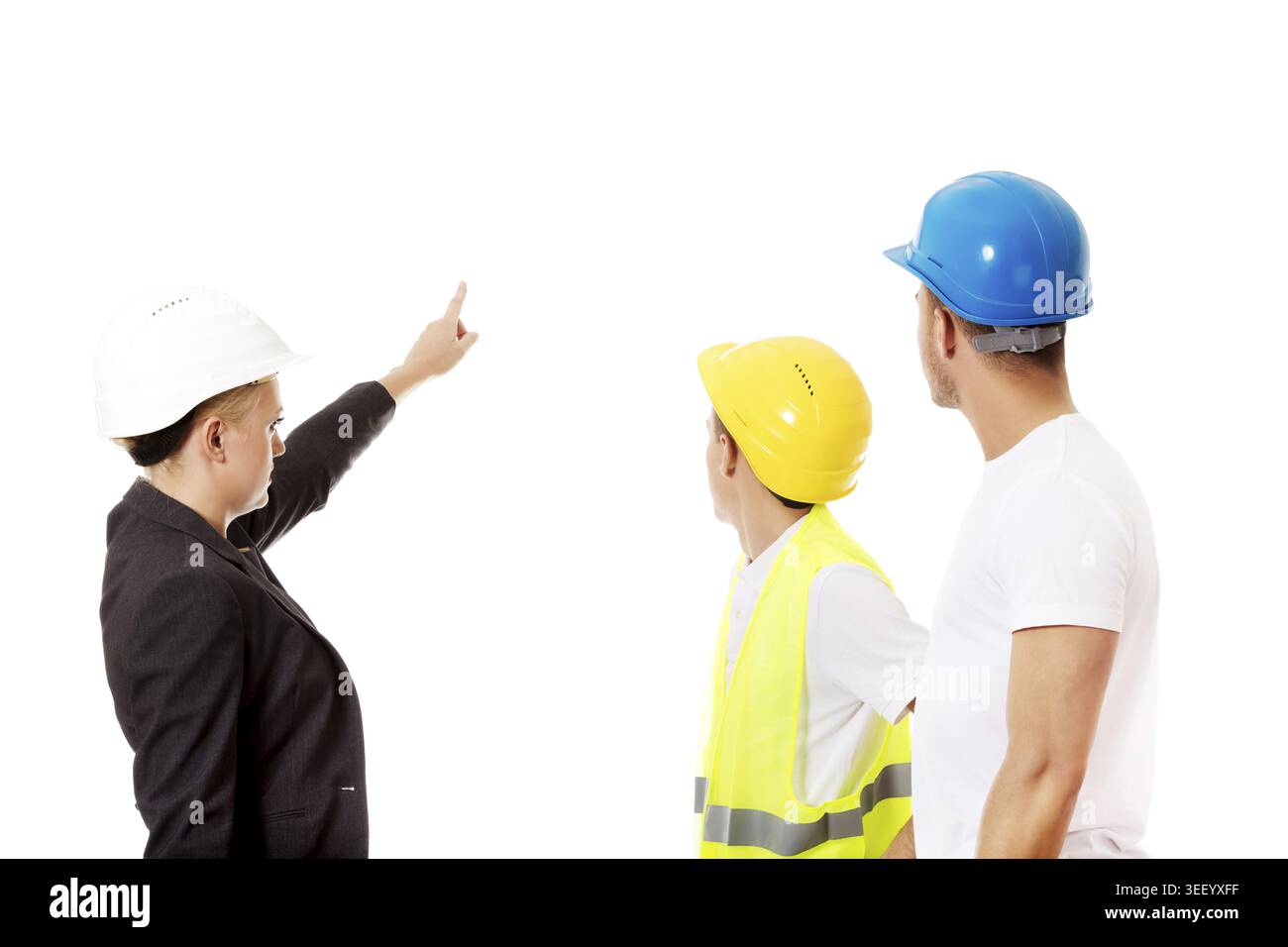 Female engineer talking with two builders and pointing for something Stock Photo