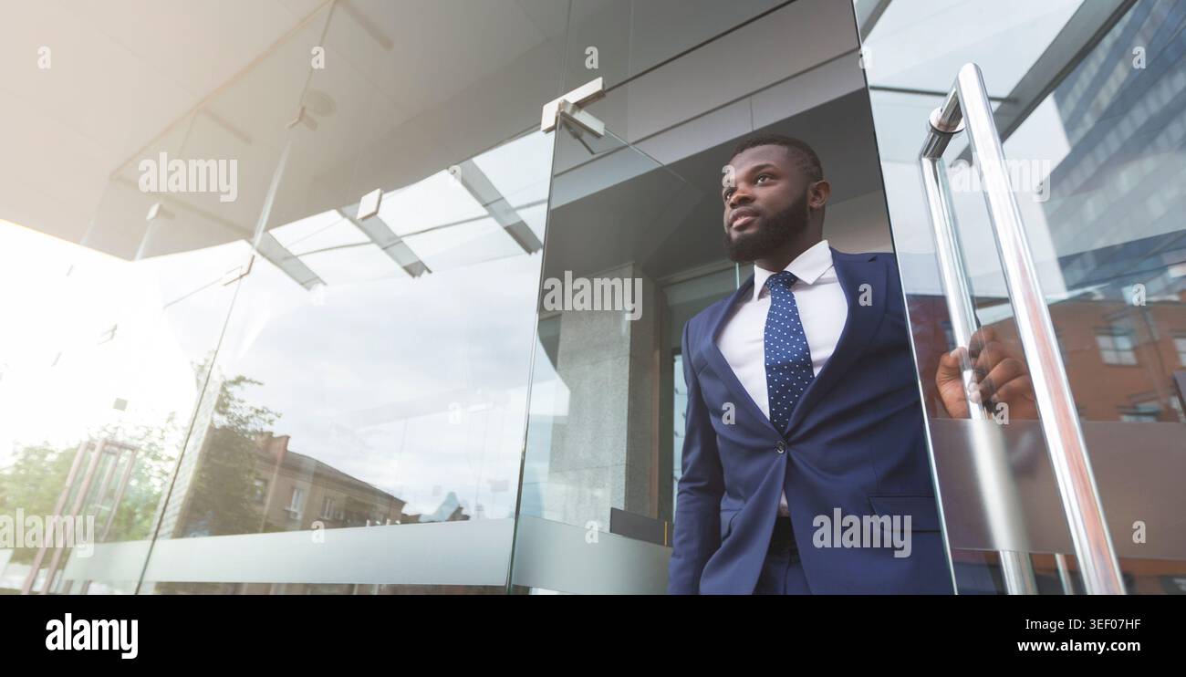 Young african job seeker leaving building after interview Stock Photo