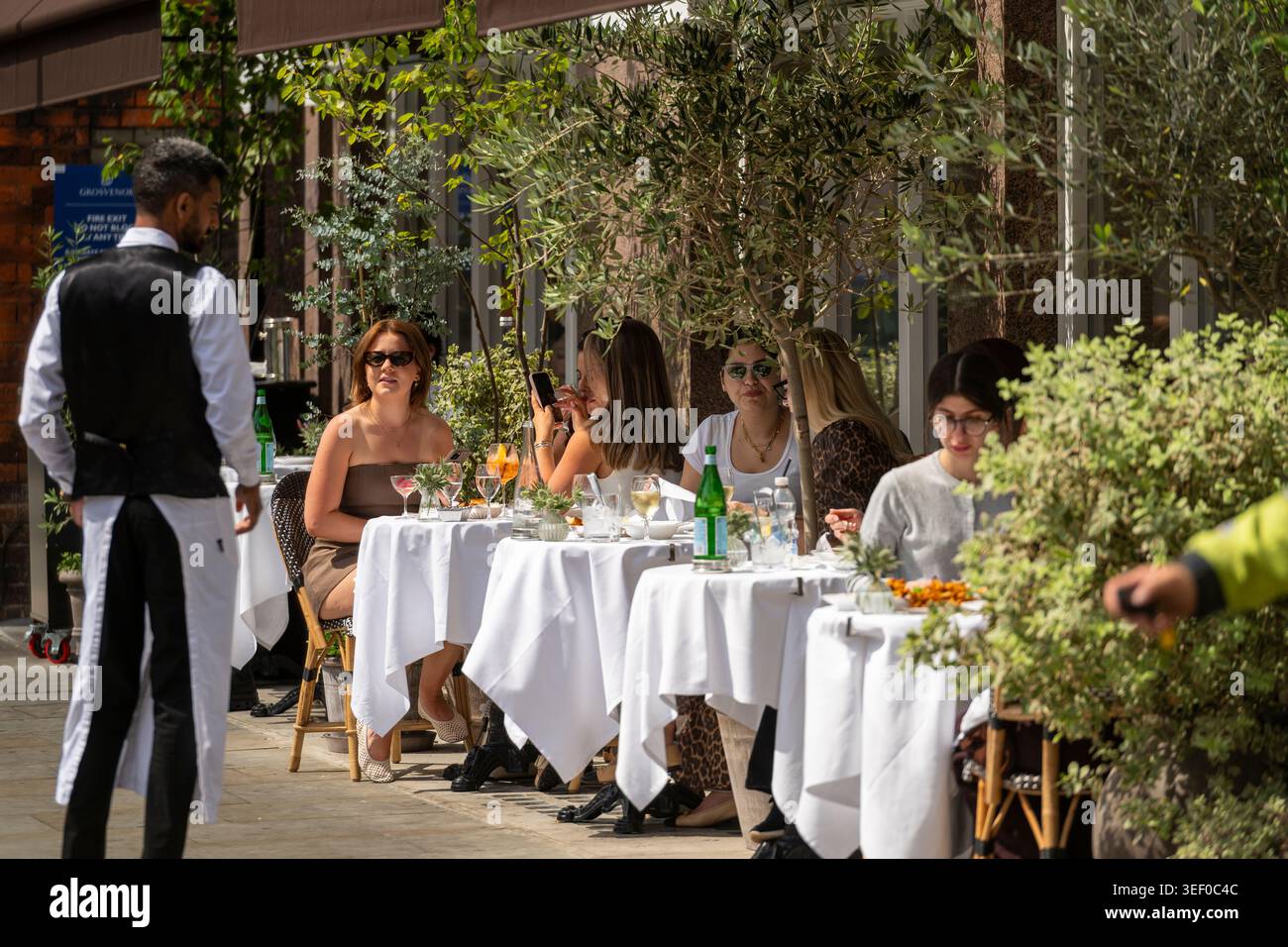 People dining outdoors at restaurants in Mayfair, London during summer. Stock Photo