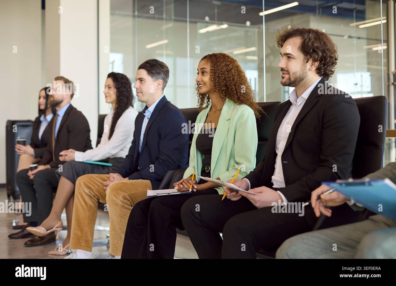 Coworkers listening at corporate training seminar, taking notes during team meeting Stock Photo