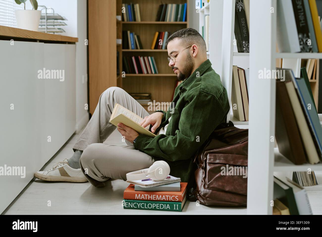 Adult Hispanic Man Studying in Library for Migrant Education Stock Photo