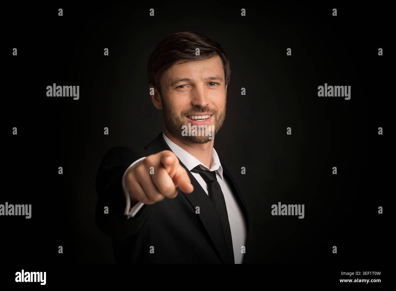 Businessman Pointing Finger Smiling At Camera, Studio Shot Stock Photo