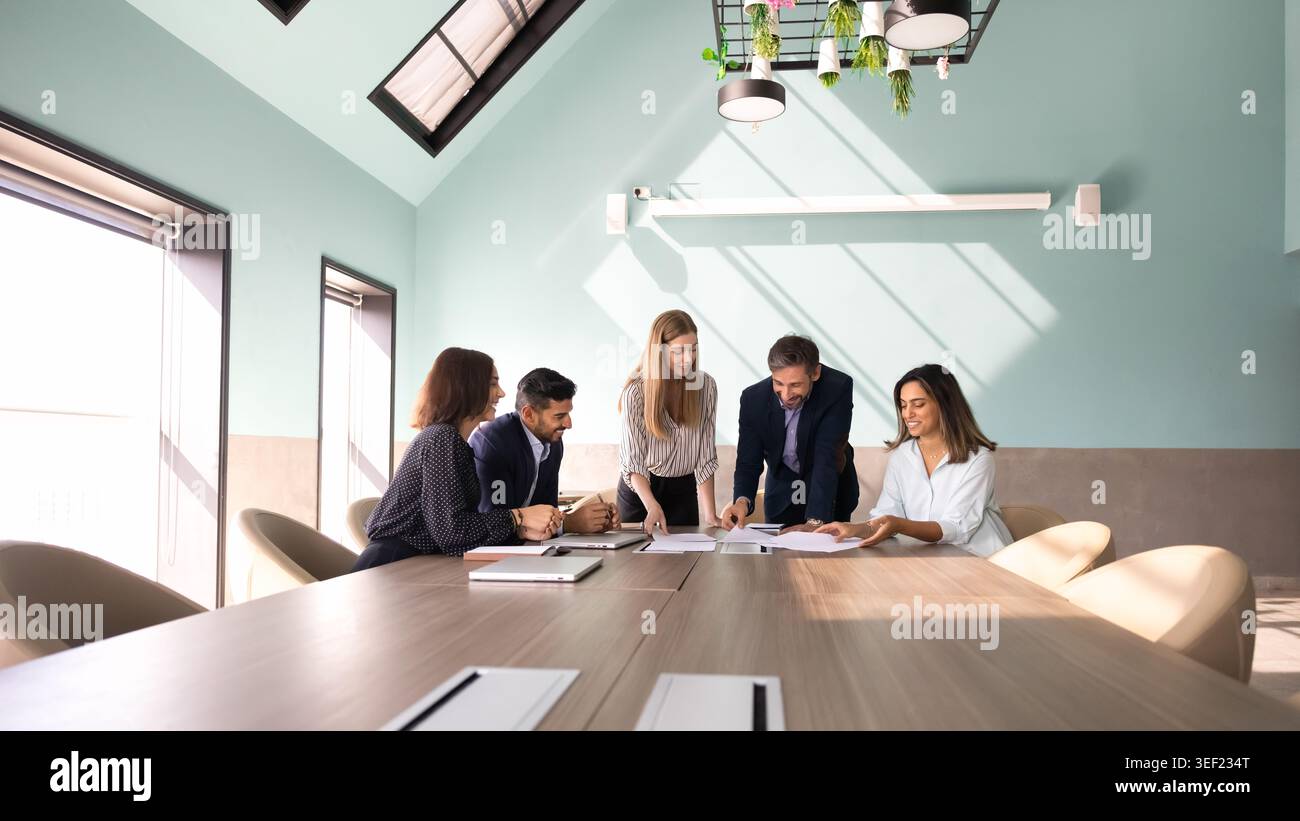 Businesspeople reviewing documents, discussing data, planning strategy Stock Photo