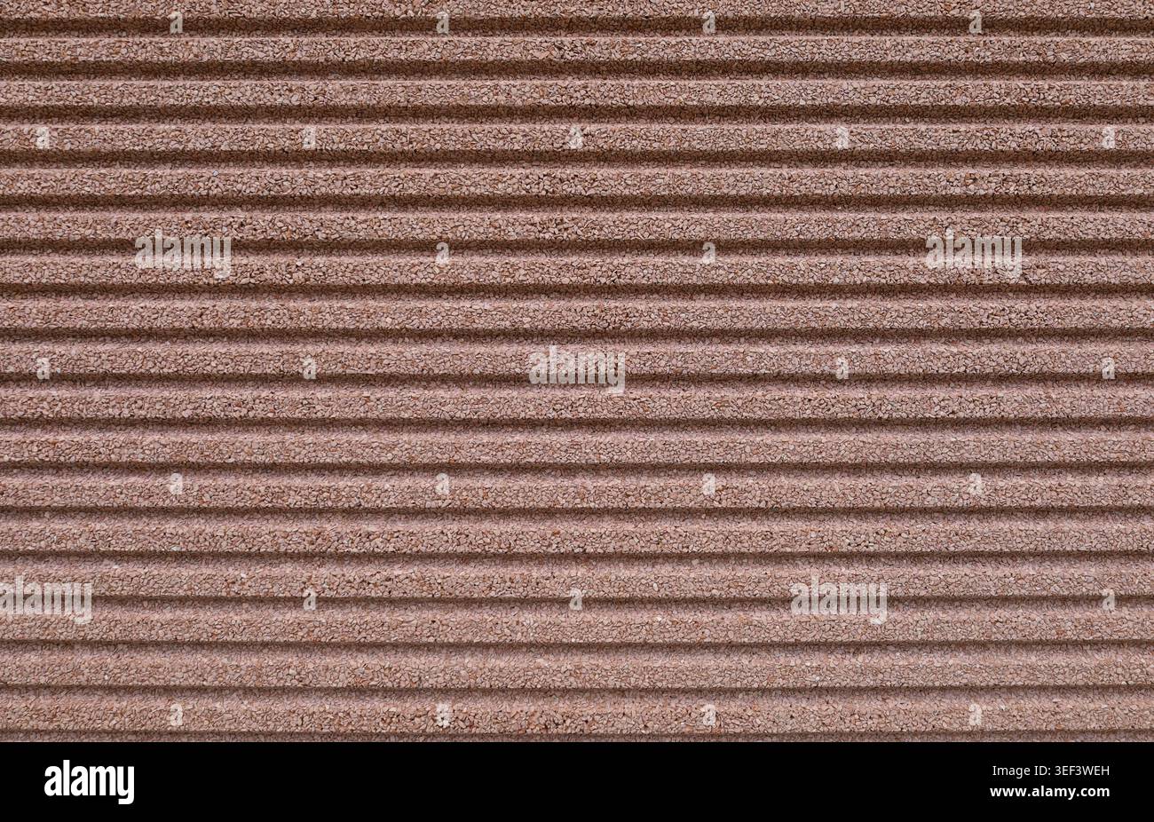 Striped brown concrete aggregate wall. Full frame. Background and texture. Stock Photo
