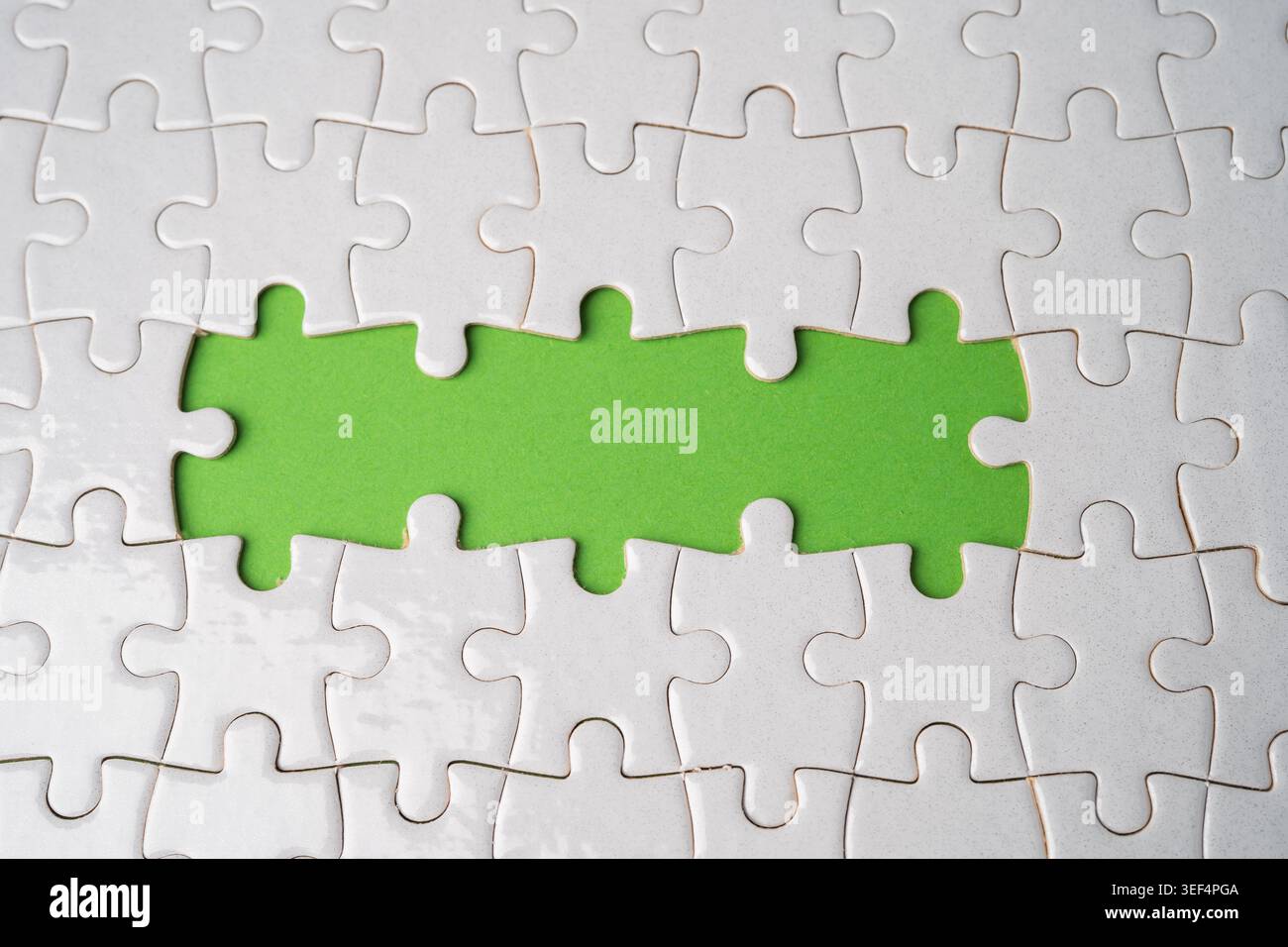 Jigsaw puzzle on green background, business teamwork, problem solving concept. Stock Photo