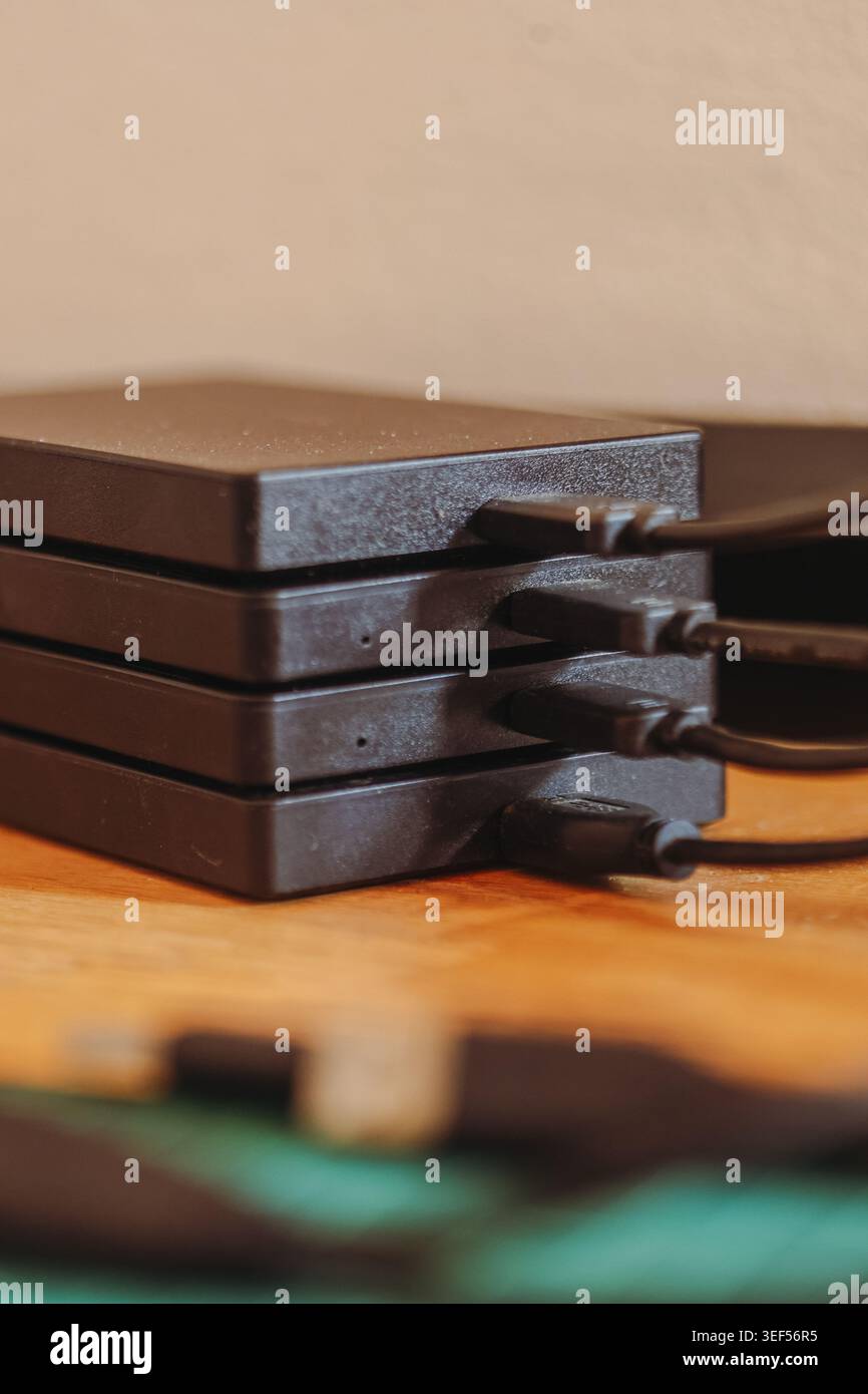 Stack of portable external hard drives representing digital storage backup and data security technology Stock Photo