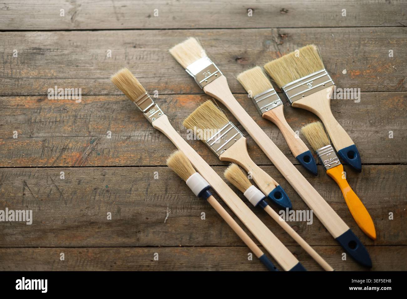 Paint brushes on rustic wooden background. Stock Photo