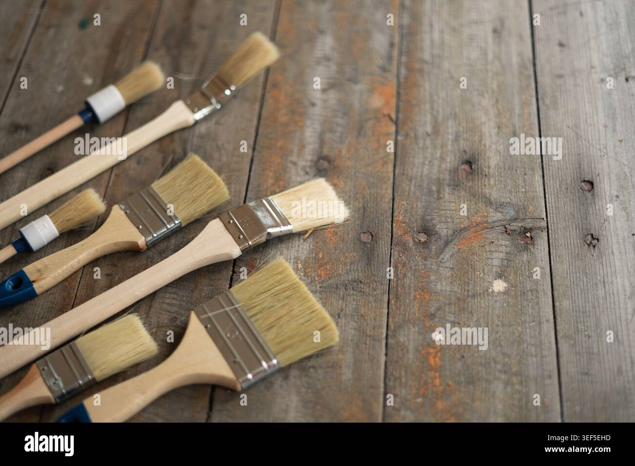 Paint brushes on rustic wooden background. Stock Photo