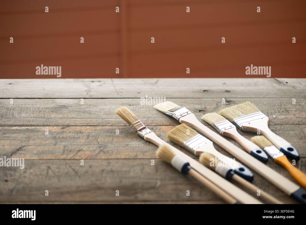 Paint brushes on rustic wooden background. Stock Photo