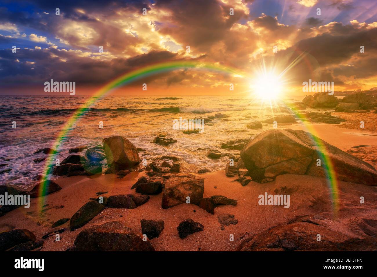 sunset over huge stones on a sandy beach. wonderful summer vacation season at the black sea. calm waves washing the sand shore. nature background with Stock Photo
