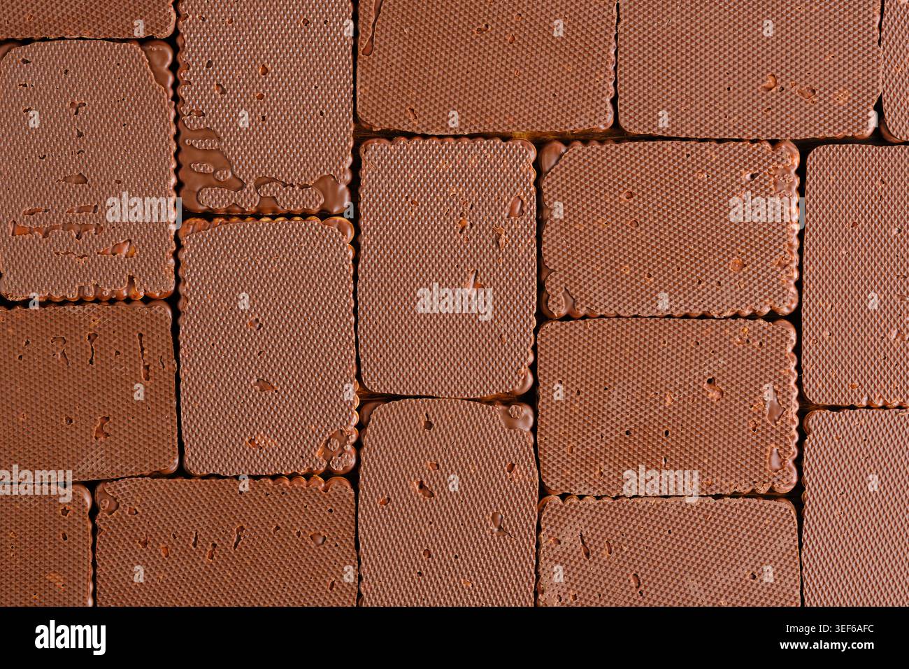 Top down flat lay textured chocolate biscuits arranged in seamless rectangular grid pattern Stock Photo