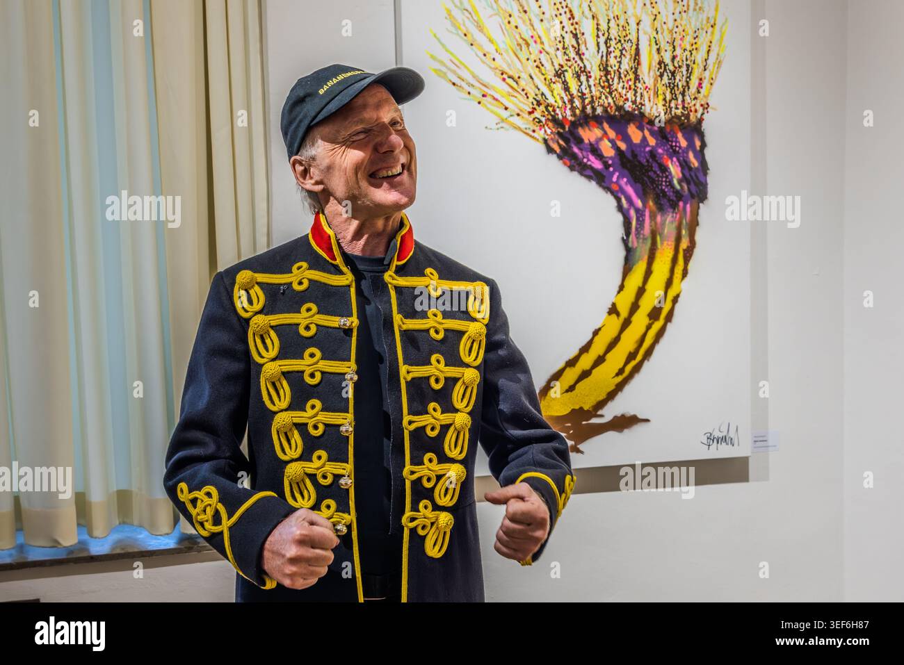Thomas Baumgärtel in front of the ‘Lower Rhine Banana’ motif, a banana that tapers into a pollarded willow, a tree typical of his home region, the Lower Rhine. Thomas Baumgärtel at the opening of the exhibition “40 Years of Bananensprayer” at the Museum of the Lower Rhine Soul in Grevenbroich.  The exhibition project NiederrheinTour 2026 presents 40 groups of works spanning 40 years at 40 art venues Stock Photo