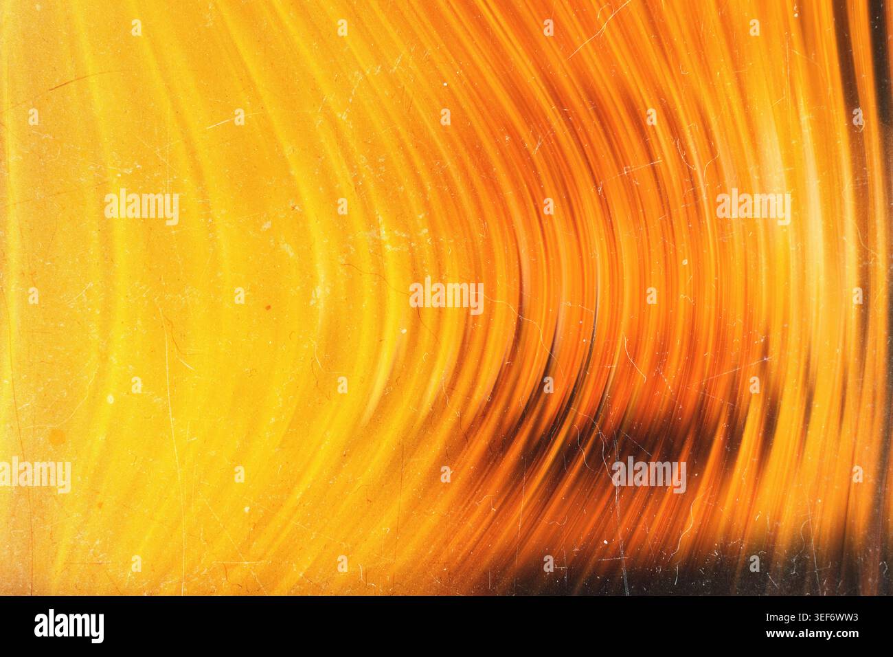 Golden glowing abstract background with sweeping warm curved light lines and grunge texture Stock Photo