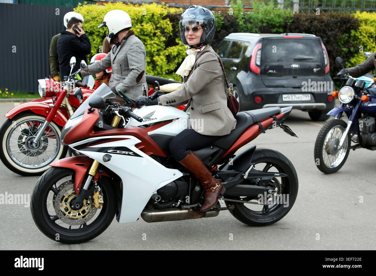 Participants wearing strict dress code and crash helmets during Distinguished Gentleman’s Ride in central Moscow. The Distinguished Gentleman’s Ride unites classic and vintage styled motorcycle riders from all over the world to raise funds and awareness for prostate cancer research and men’s mental health. Rules of events includes classic or retro motorcycles, dress code with classic suit and dresses, respect and courtesy on the road Stock Photo