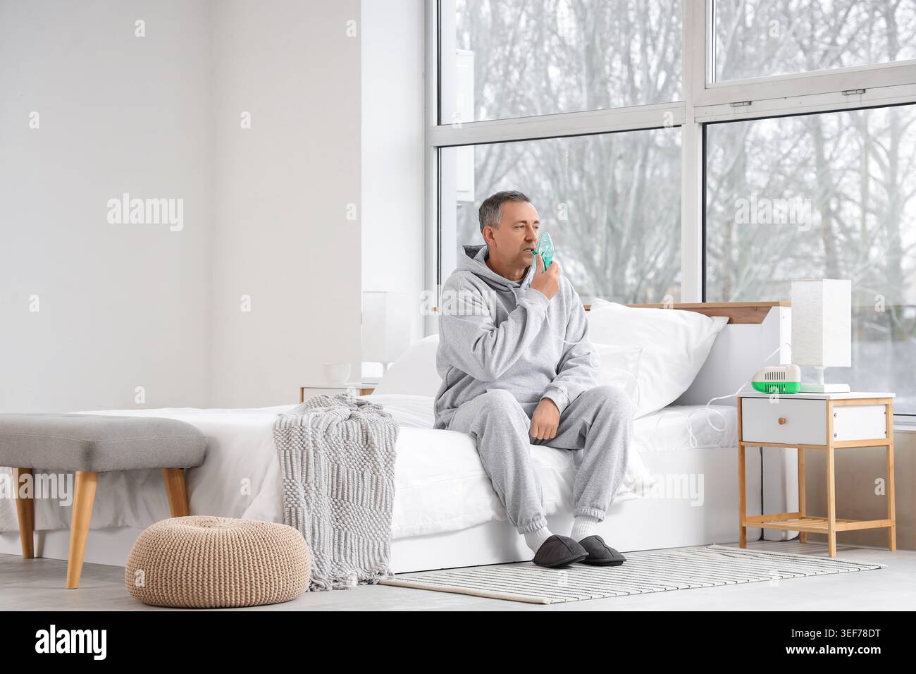 Mature man using nebulizer in bedroom Stock Photo