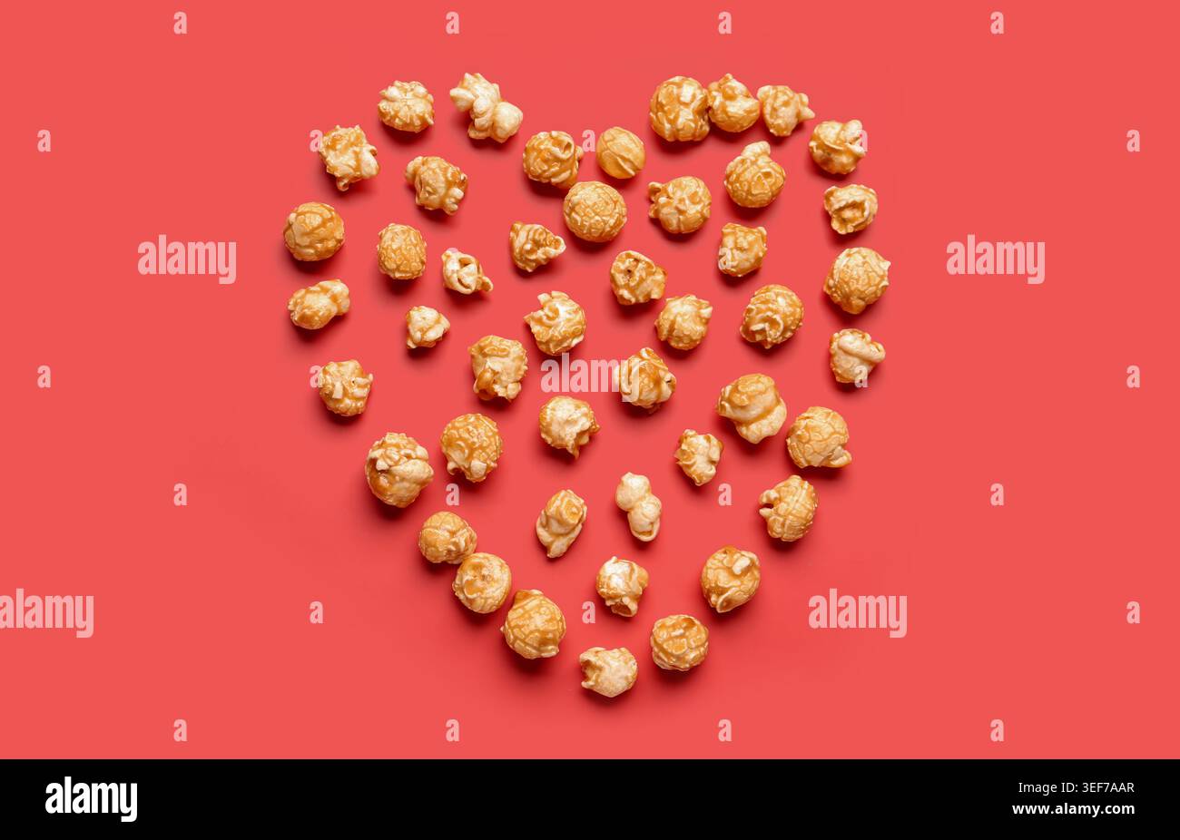 Heart made of crispy popcorn on red background Stock Photo