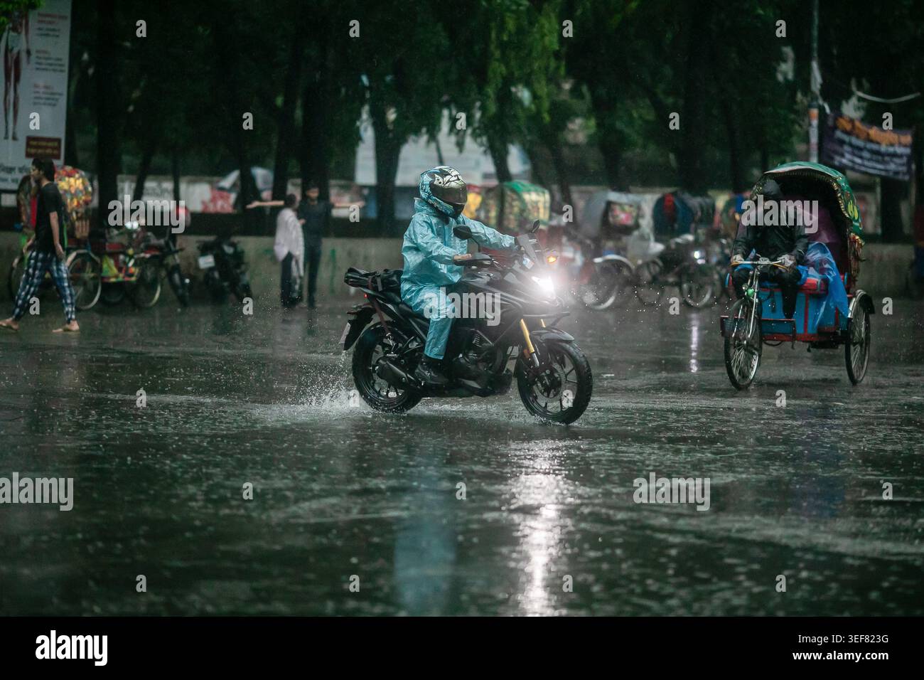 Dhaka, Bangladesh. 13th May, 2026. A biker seen riding along the street on a rainy day. The heavy monsoon downpour made travel slow and dangerous. Credit: SOPA Images Limited/Alamy Live News Stock Photo