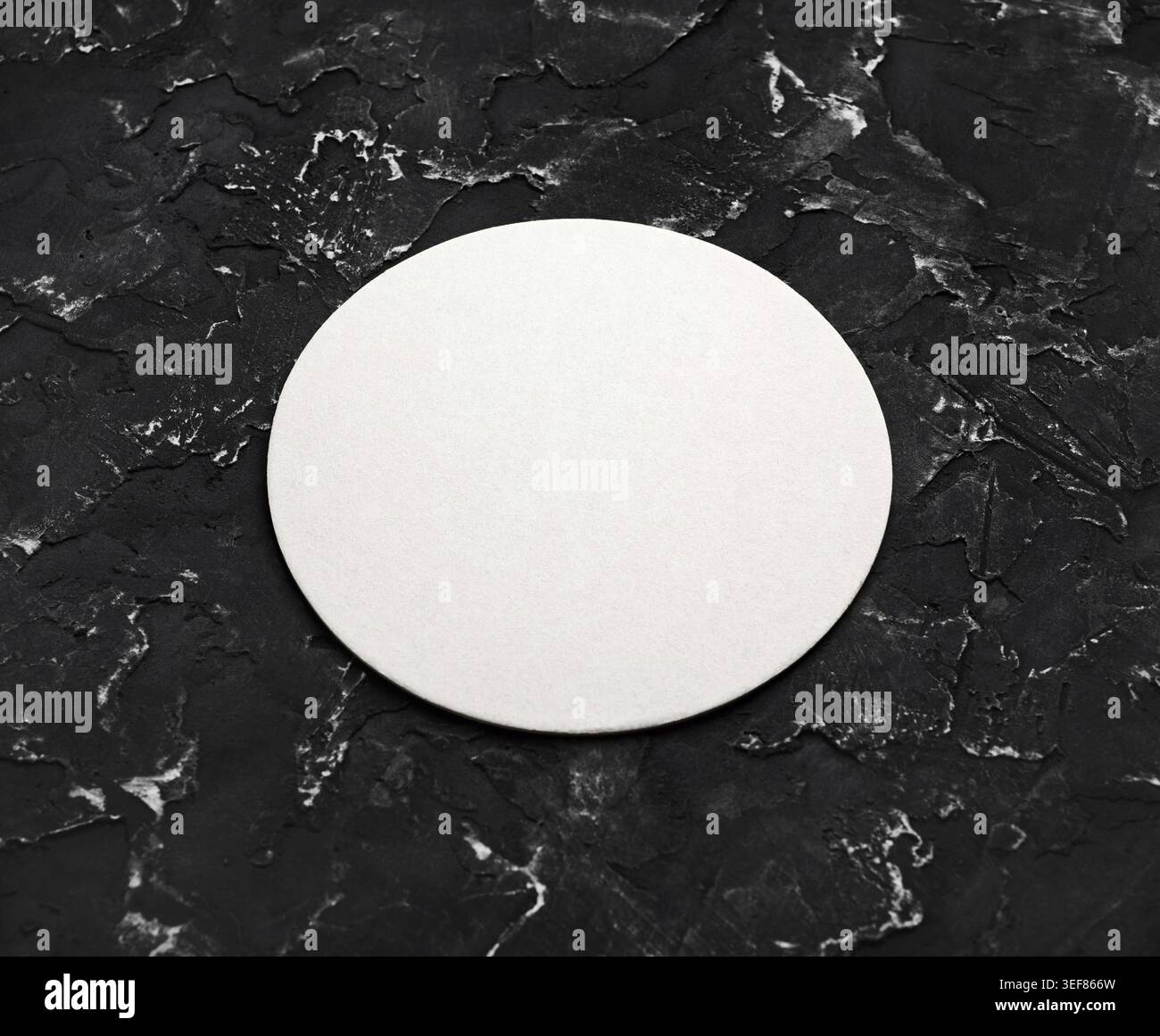 Blank white round beer coaster mockup on black textured surface. Responsive design mockup Stock Photo