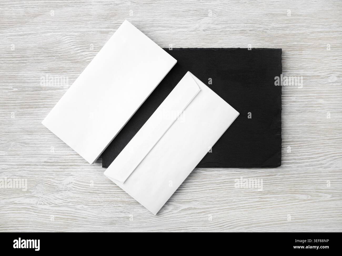 Blank white envelopes on stone board. Copy space. Flat lay Stock Photo