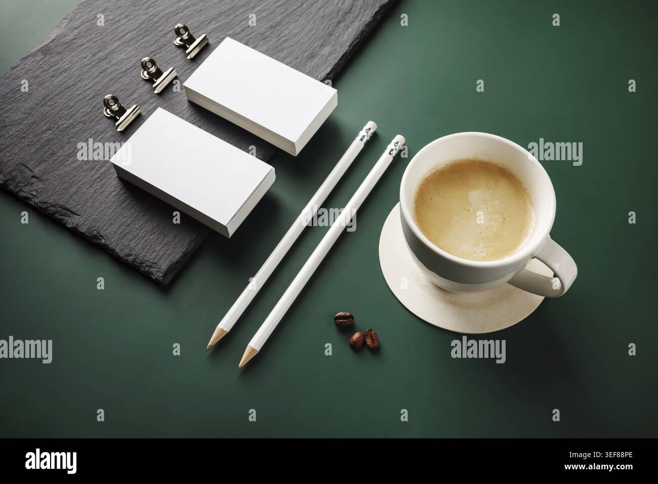 Blank stationery and coffee cup on green background Stock Photo