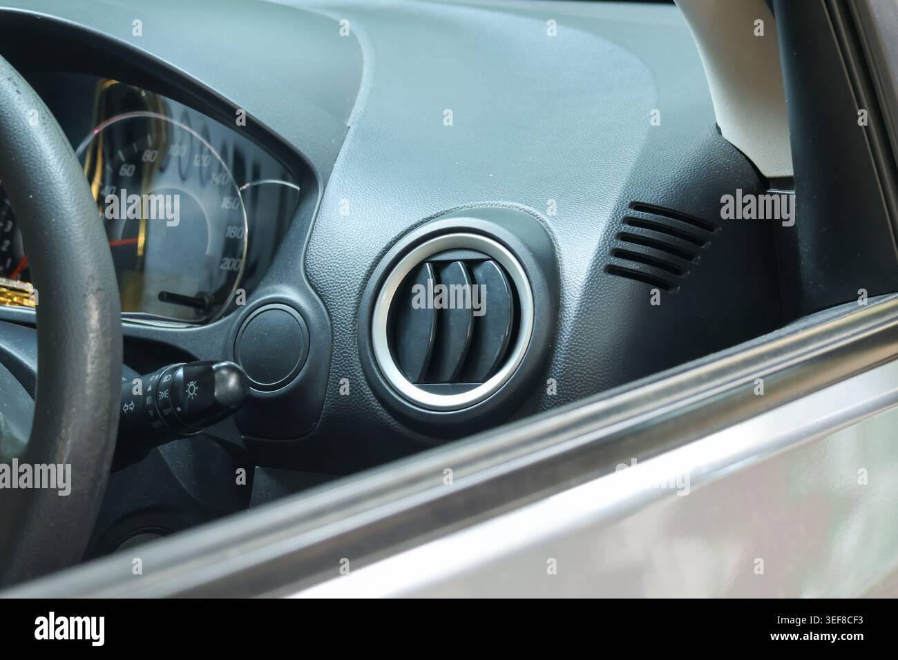 Close up detail of modern car interior showing clean plastic dashboard with an air conditioning vent in functional vehicle providing auto climate cont Stock Photo