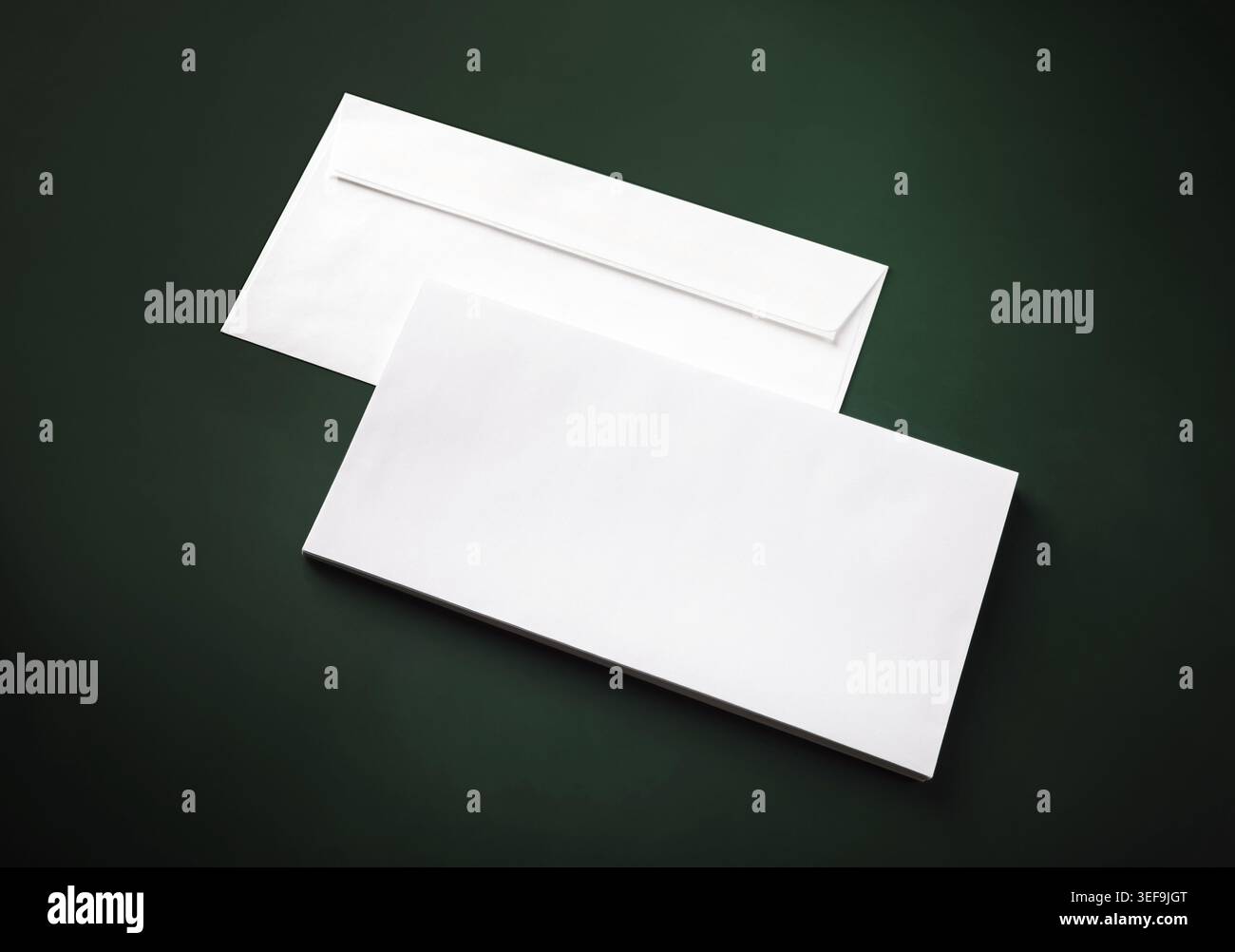 Two blank white envelopes on green background. Copy space Stock Photo