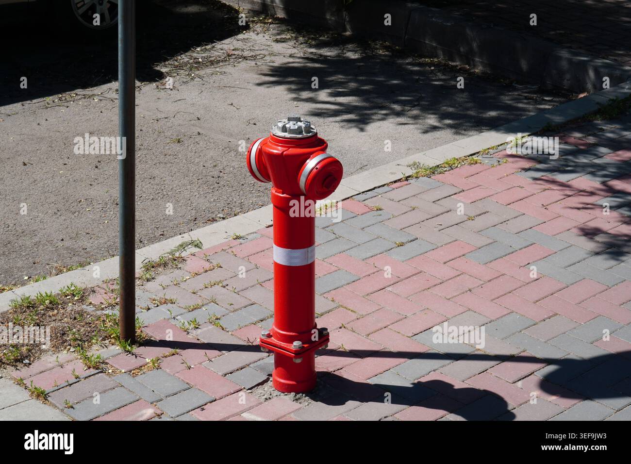 Red fire hydrant on paved footway in Bucharest, Romania Stock Photo