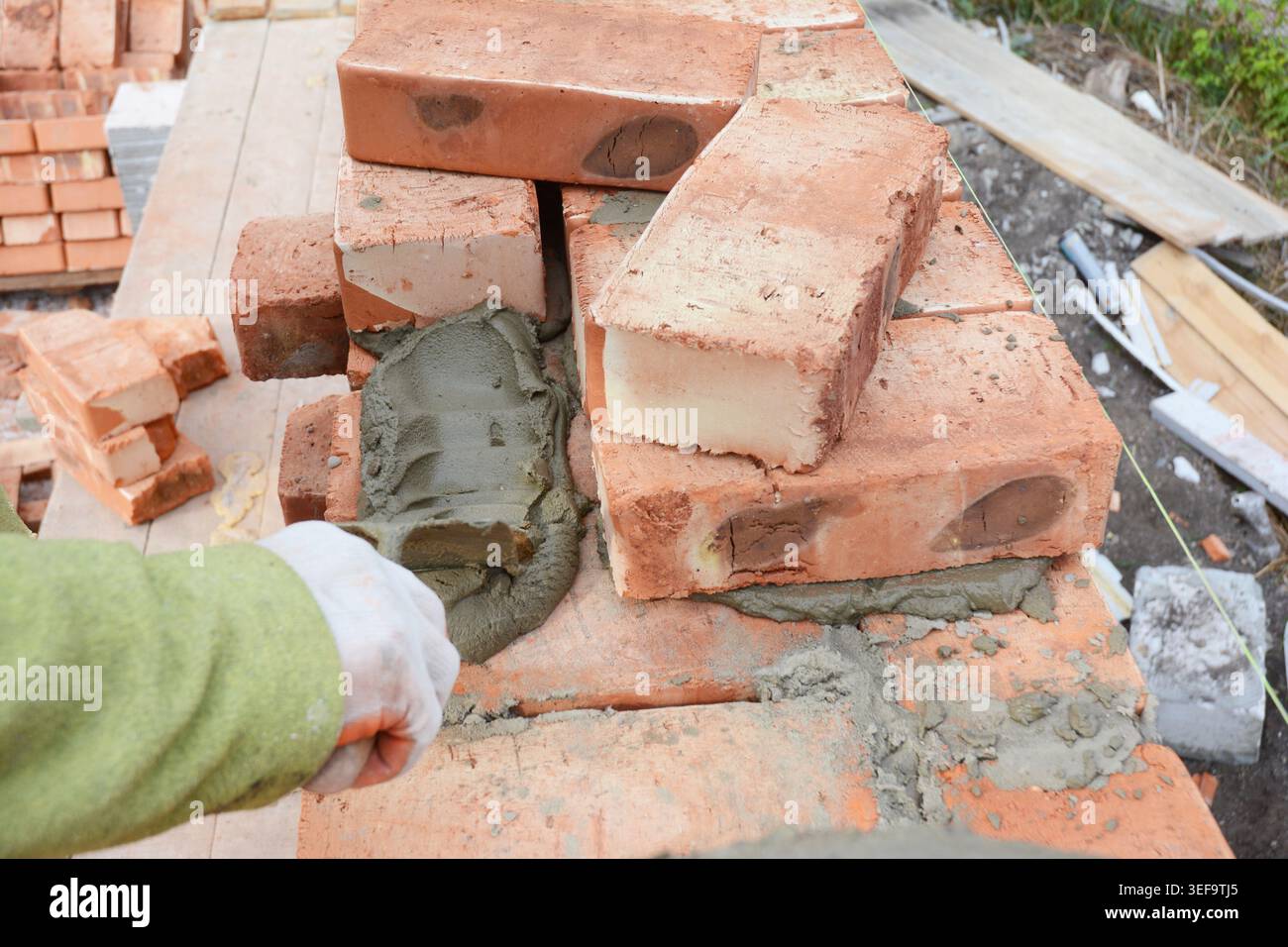 Professional construction worker laying bricks on house construction site. Stock Photo
