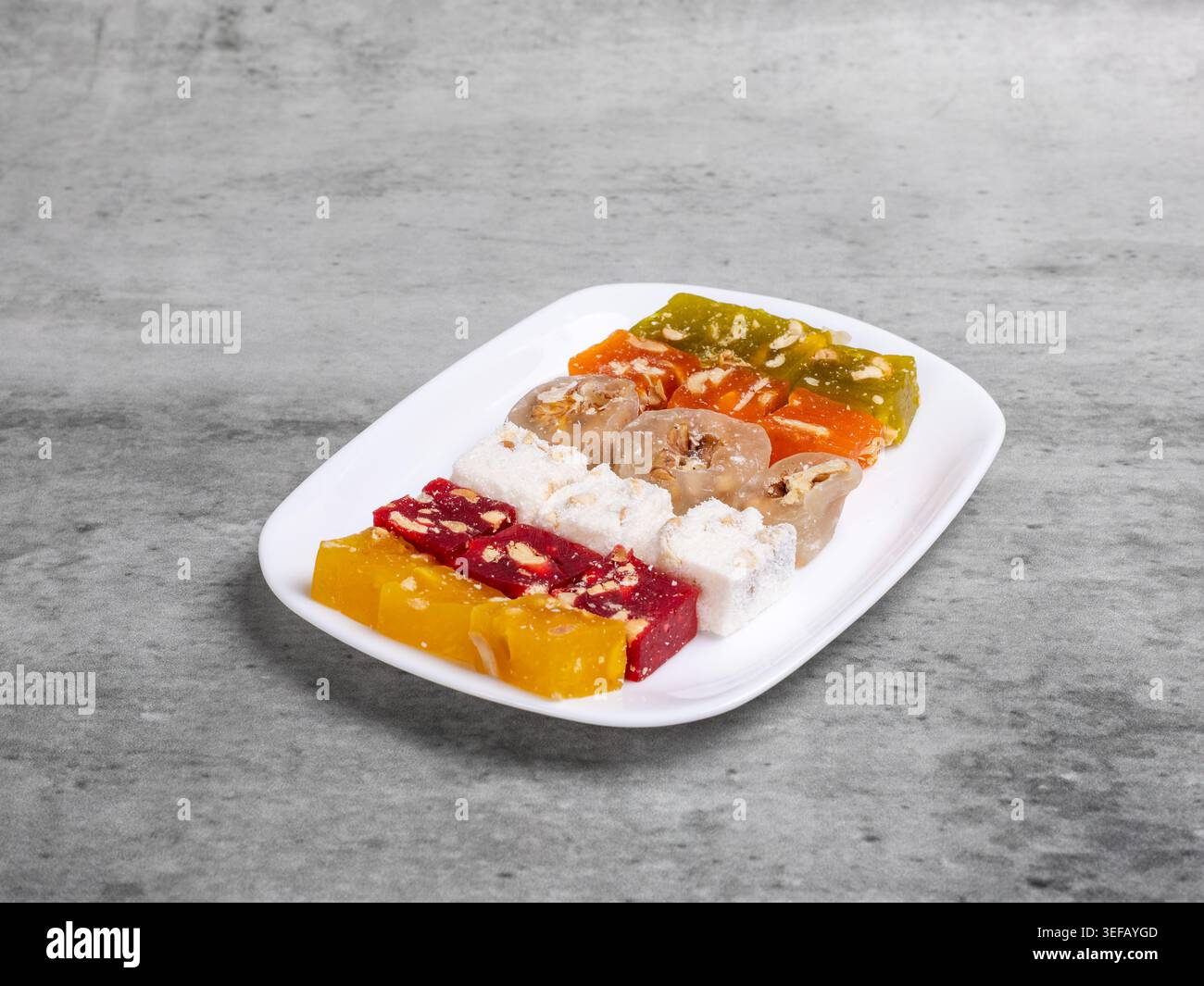 Fruit sweets with nuts on the white plate. Traditional middle eastern sweets. Stock Photo