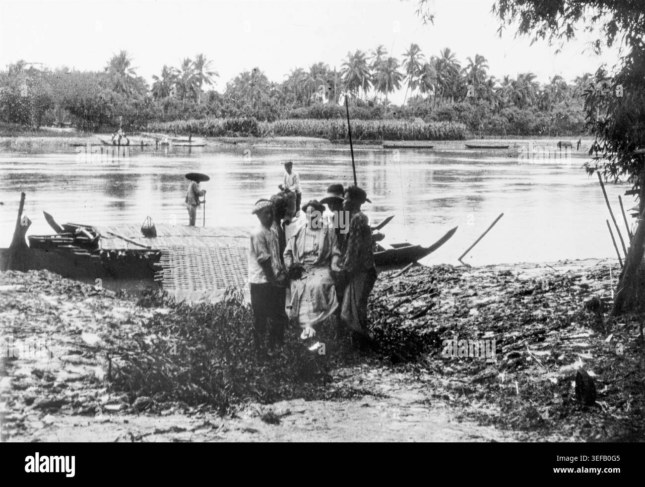 European woman is carried from a river boat by native men in Dutch ...