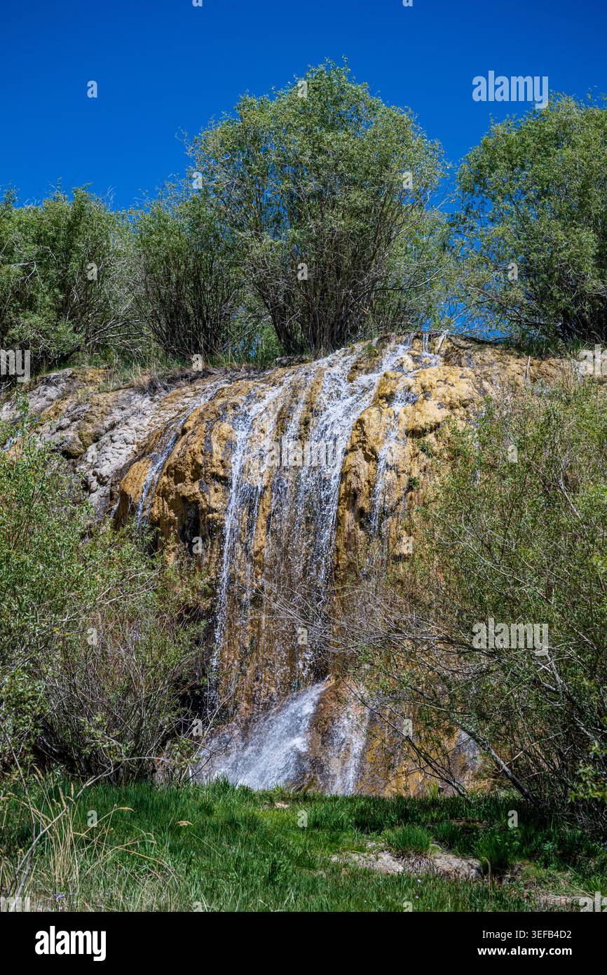 Waterfall flowing down rocks in Band-e-Amir National Park during bright sunlight in Afghanistan Stock Photo
