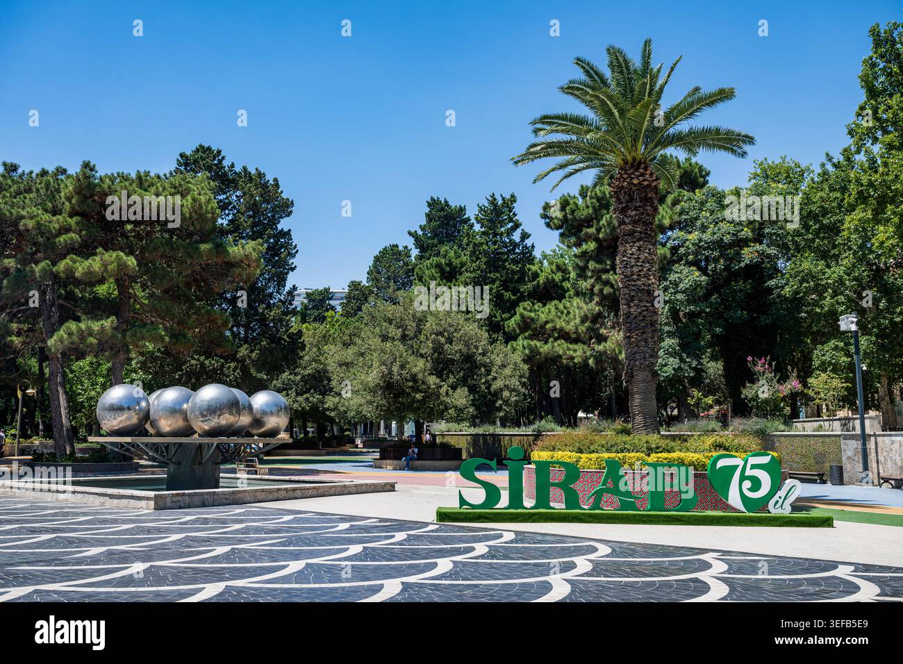 Visitors enjoy the greenery and attractions in the central square of Baku, Azerbaijan, on a sunny day in summer Stock Photo