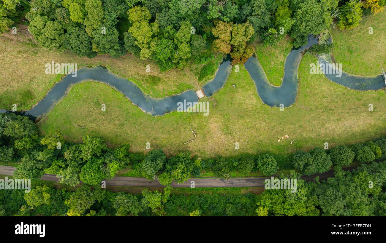 Snaking river winds through lush greenery near the Abbey of Fontenay in France Stock Photo
