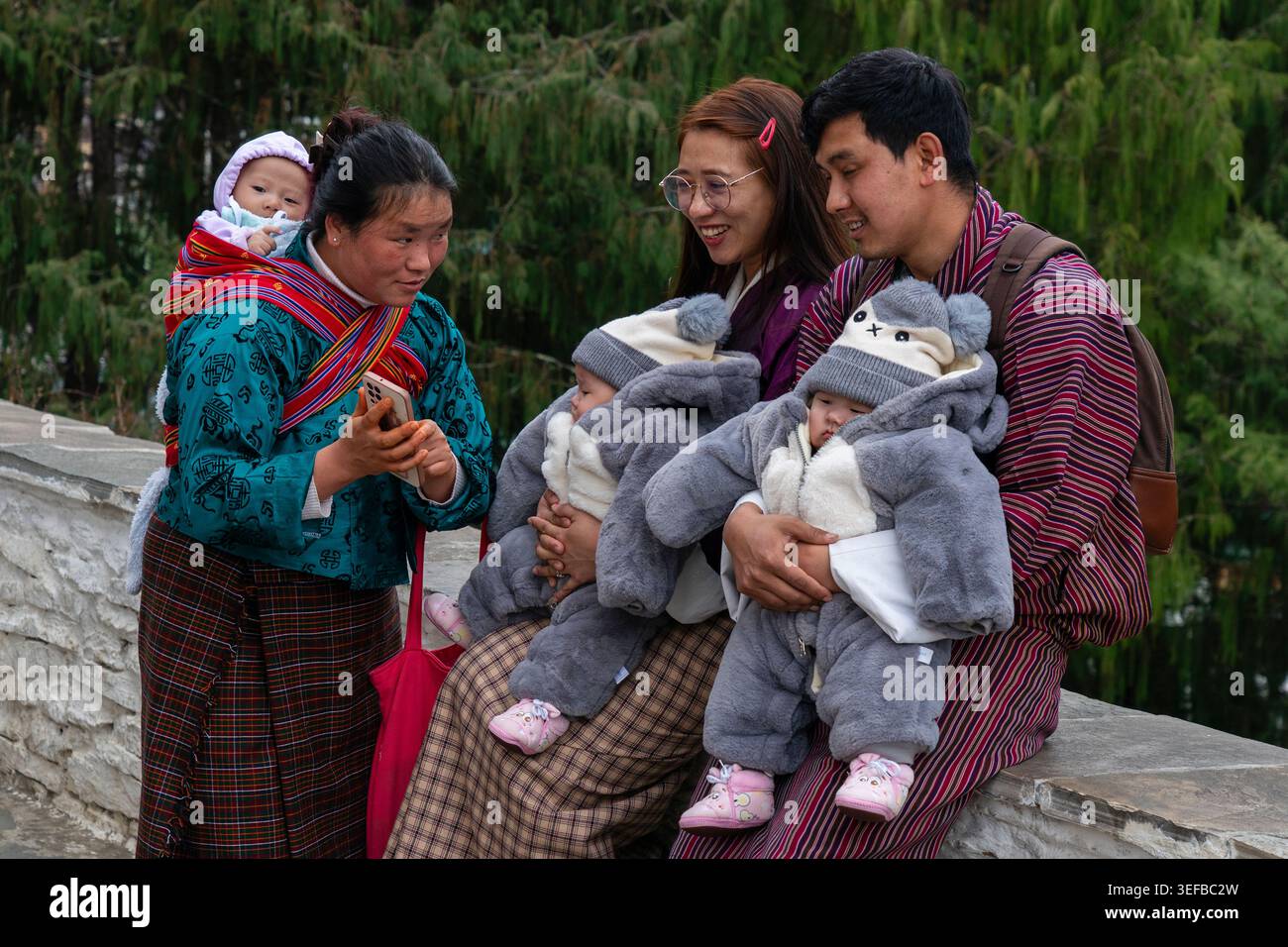 Bhutanese family enjoying time together at a temple in the chilly weather of Bhutan Stock Photo