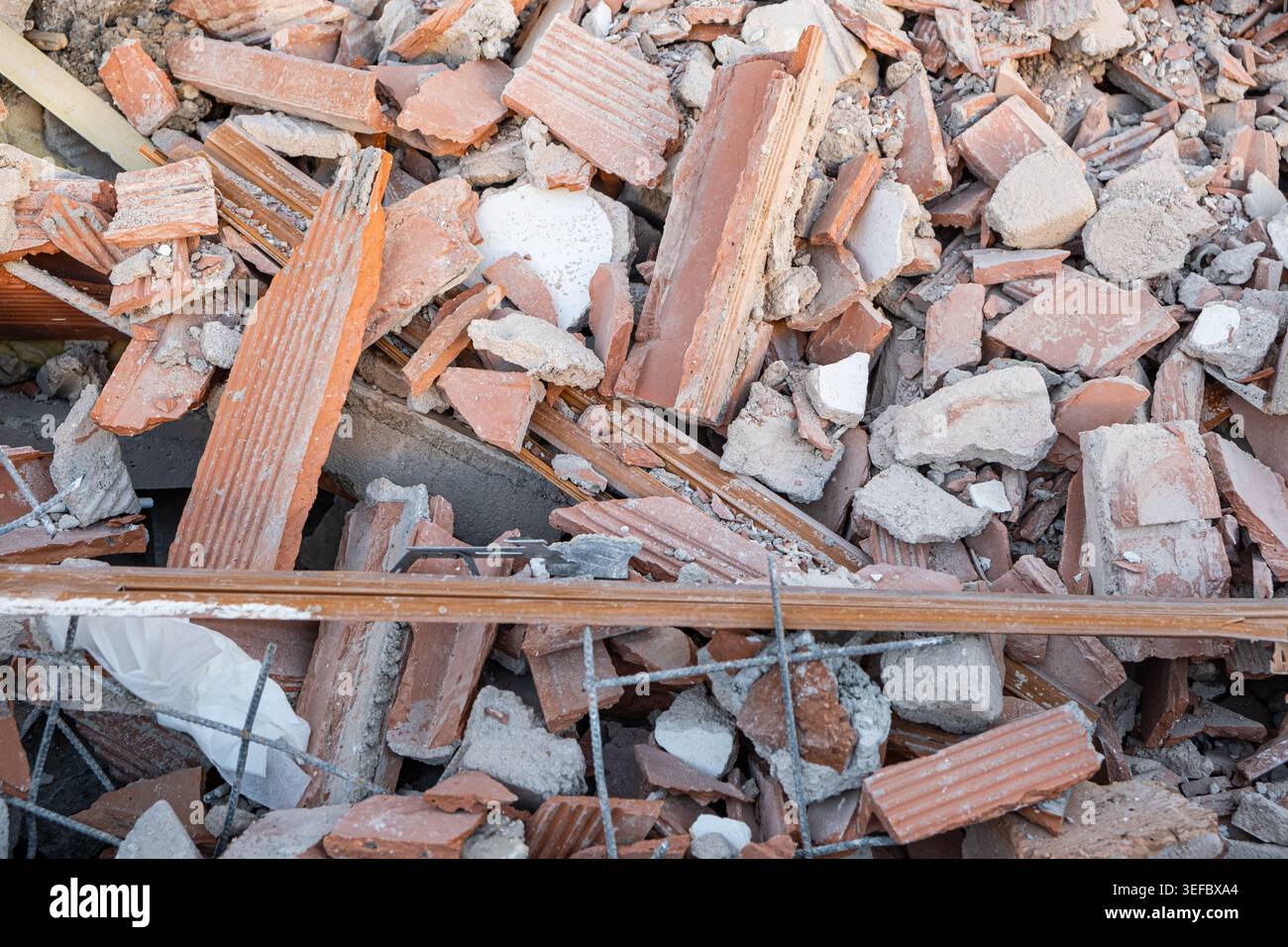 Broken red bricks and gray concrete chunks form a pile of demolition ...