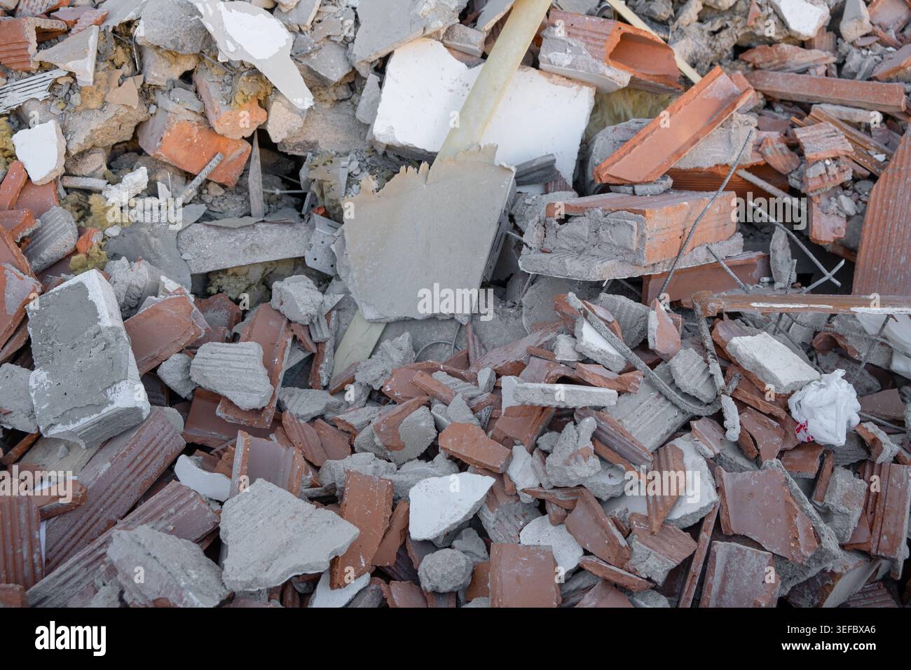 Broken red bricks and gray concrete chunks form a pile of demolition ...