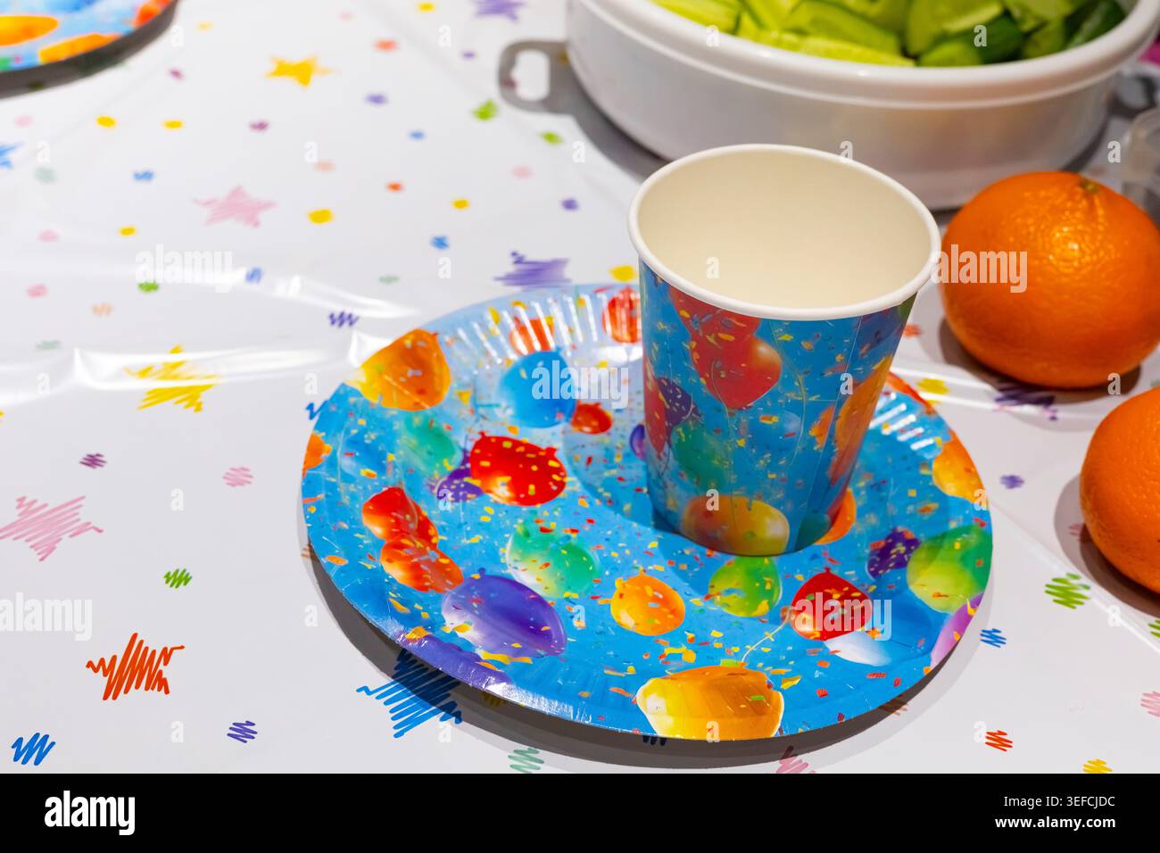 Festive table setting with painted plate and fruit, creative celebration decor, colorful party mood, family gathering. Stock Photo