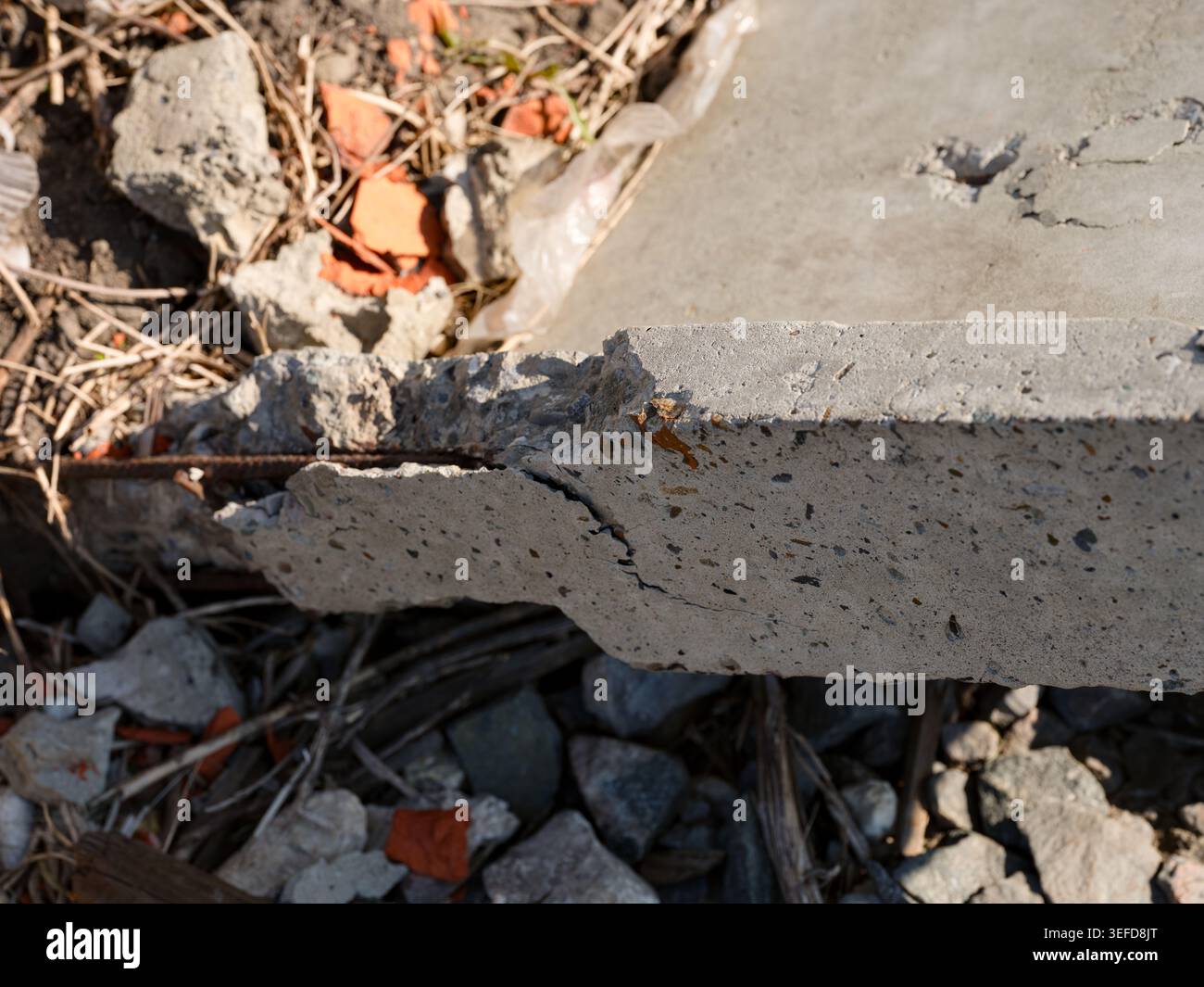 Slab Rubble A close-up shot of a broken concrete slab with visible cracks, exposing ...