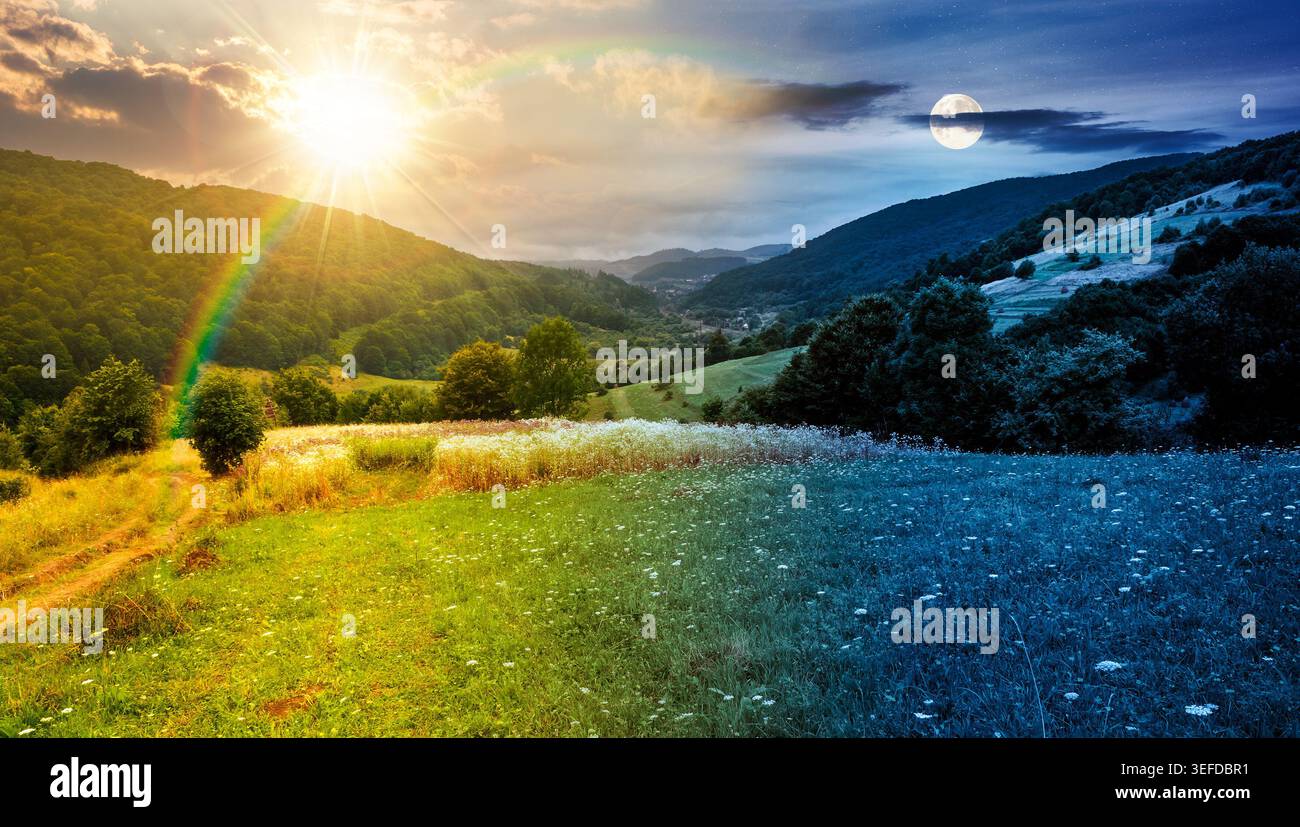 rural field on the hill. time change concept. view in to the valley at twilight. sun and moon over countryside mountain landscape. alpine pasture near Stock Photo